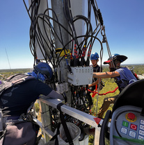 Crew in a 12ft cage reaching close to antenna